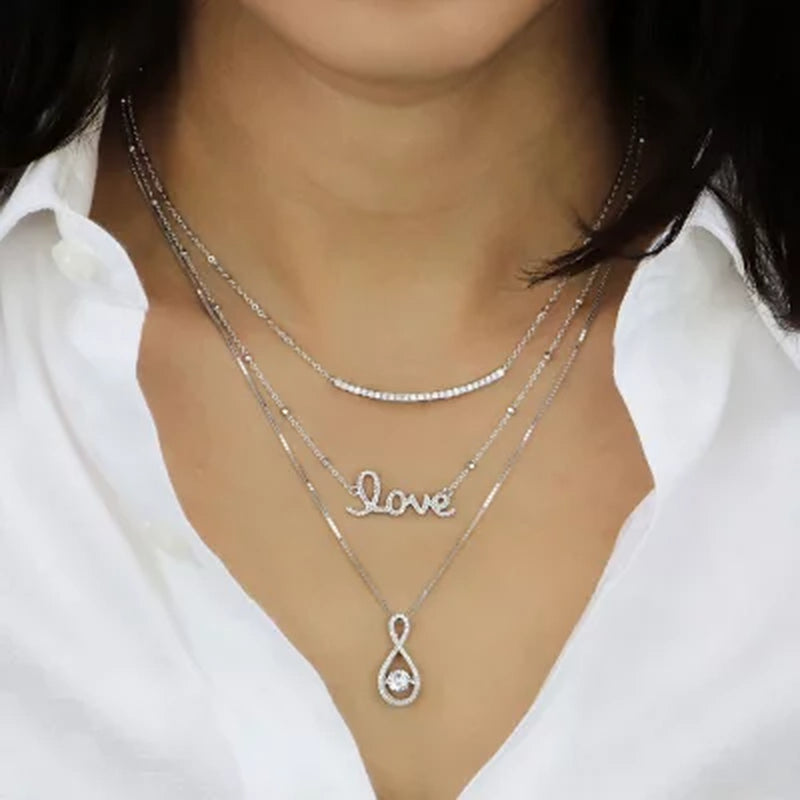 Dancing Lab Created White Sapphire and 0.12 CT. T.W. Diamond Infinity Pendant in Sterling Silver